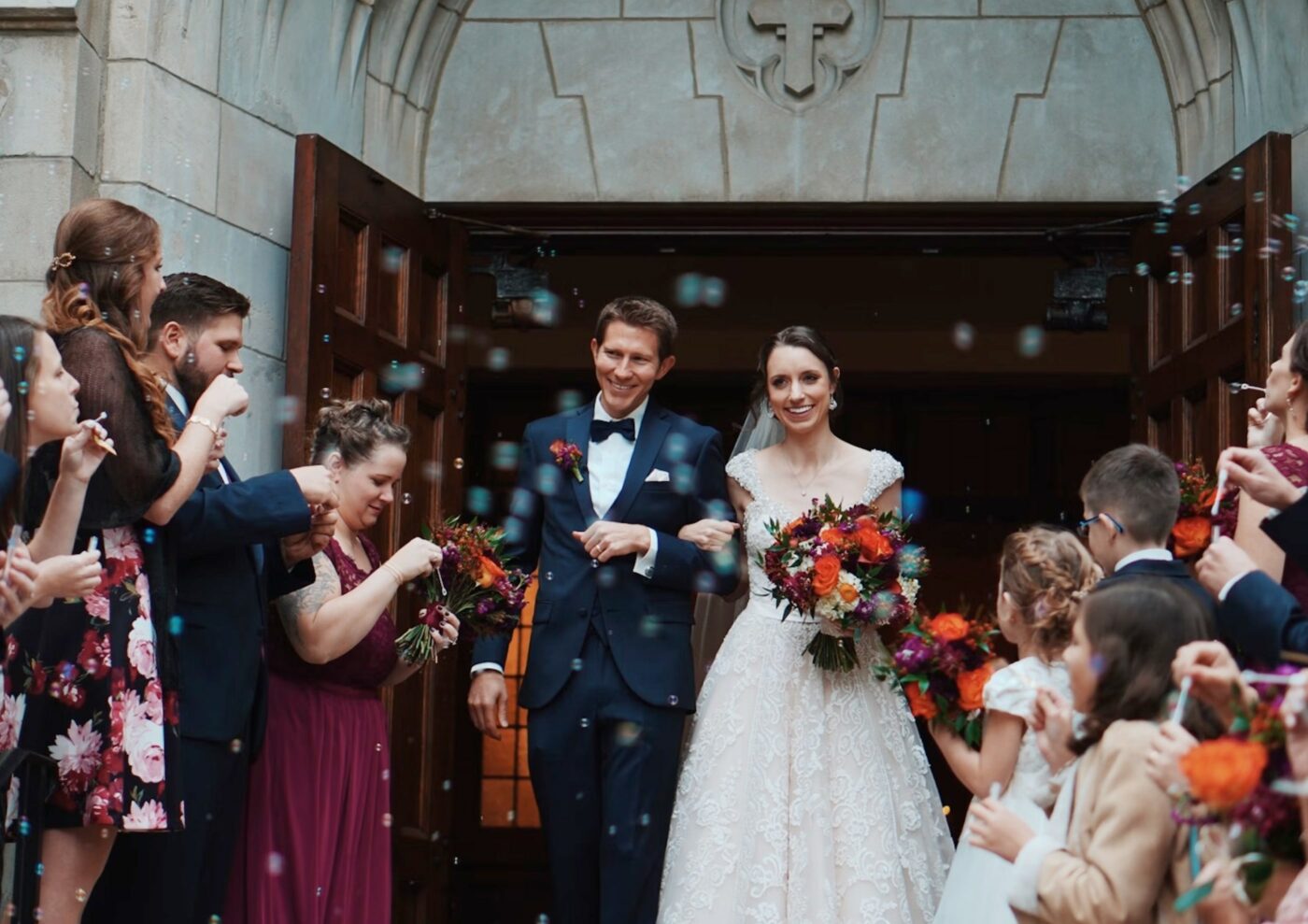 Man and woman walking out of a building after getting married. Confetti being thrown at them.