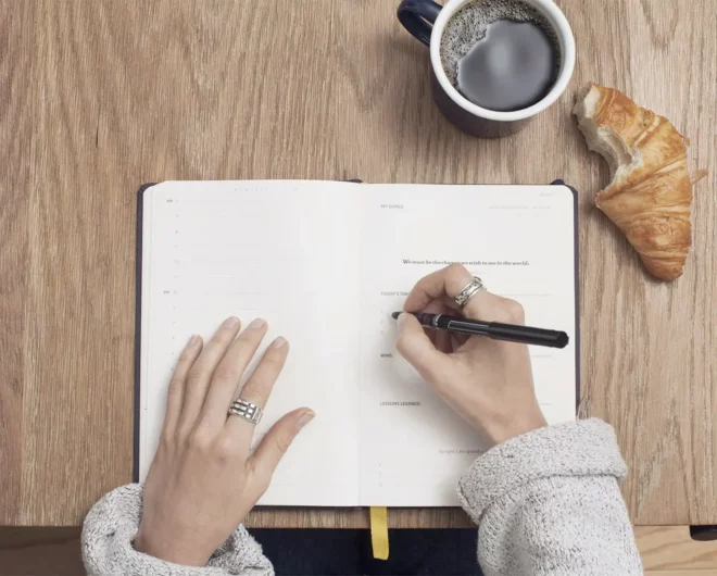 Women's hands writing in notebook